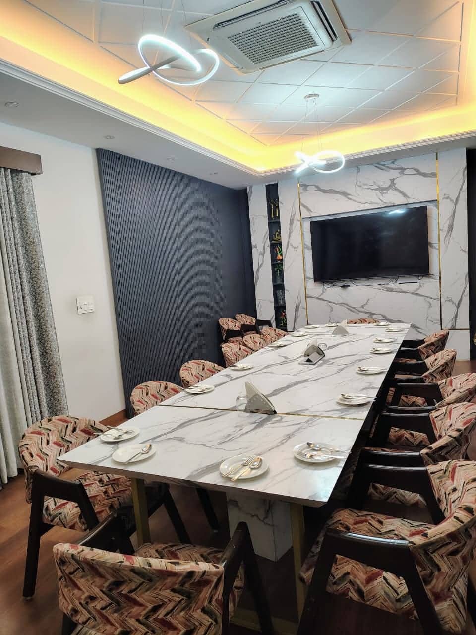 The meeting room, with a long table of chairs facing a screen on the wall