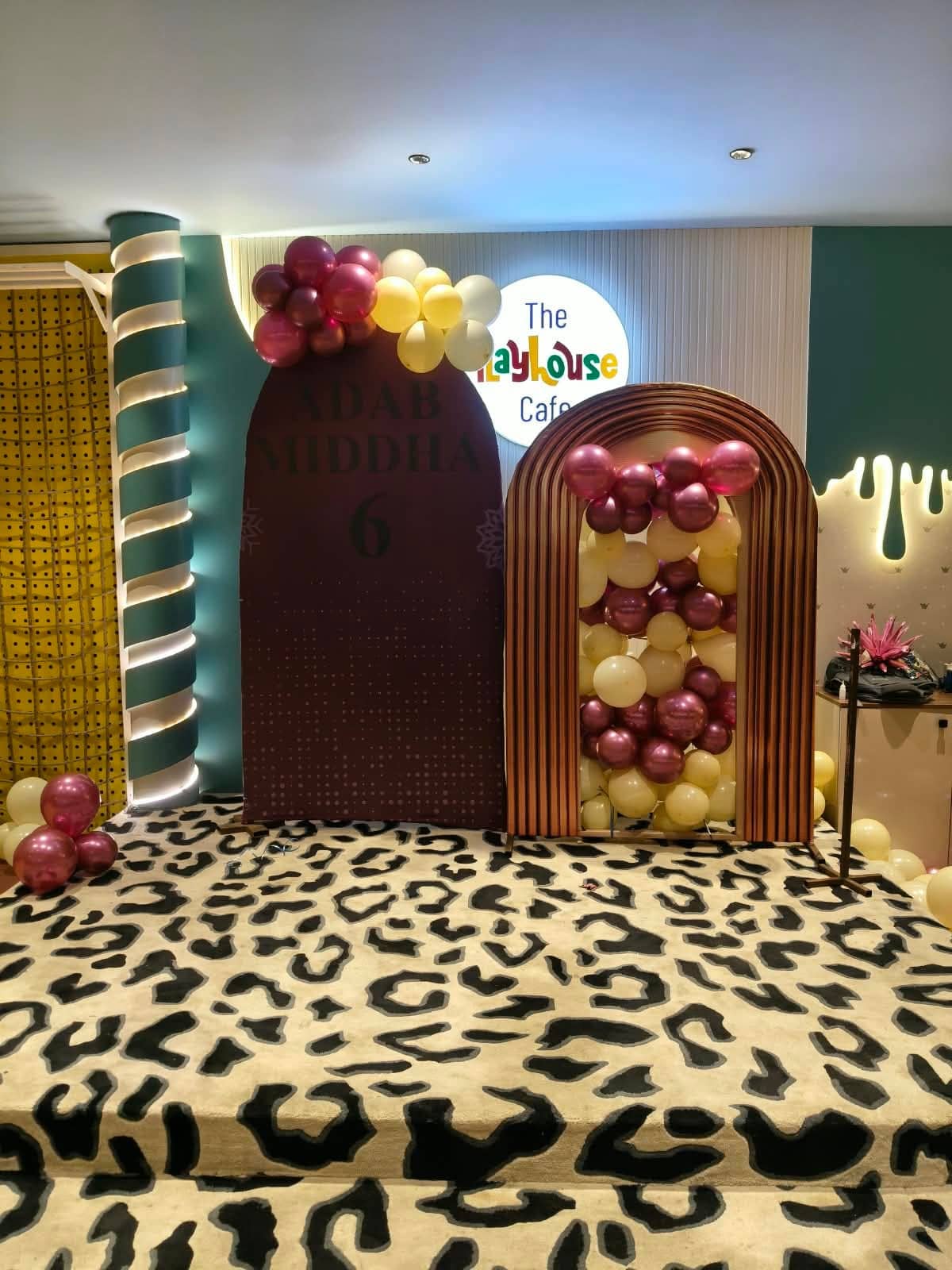 A patterned entrance carpet leading past a floral arch towards a function area