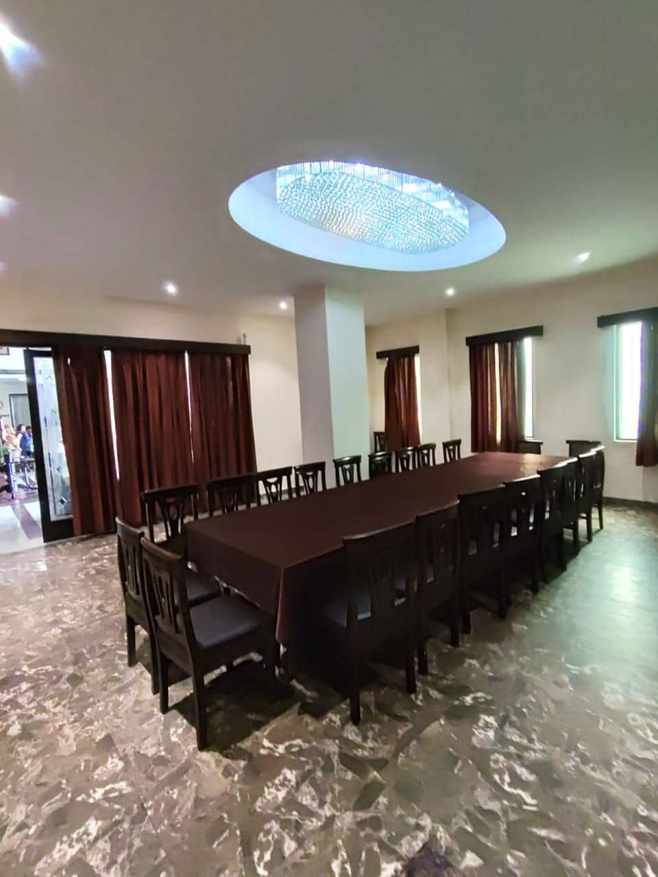 A side view of the meeting room's long table and chairs against a marbled wall