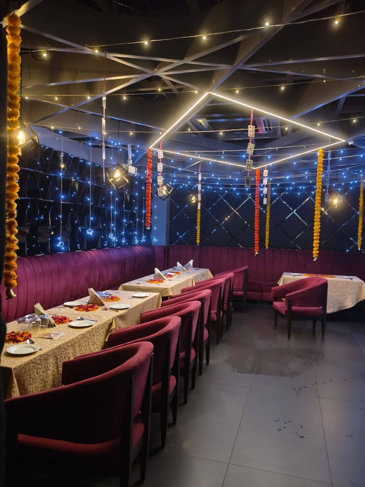 A wide view of the private hall showing formal table settings beneath draped ceiling fabric